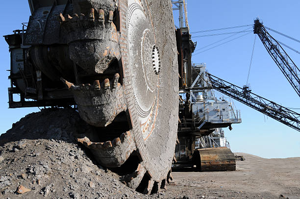 Close-up of machinery in the oil sands mine in Alberta Closeup of a bucketwheel reclaimer at oilsands mines of Fort McMurray, Alberta, Canada. open pit mine photos stock pictures, royalty-free photos & images