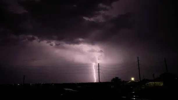 A lightning bolt striking down near a power-line pole