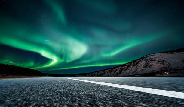 istock aurora borealis over asphalt road in Canada 1046863338