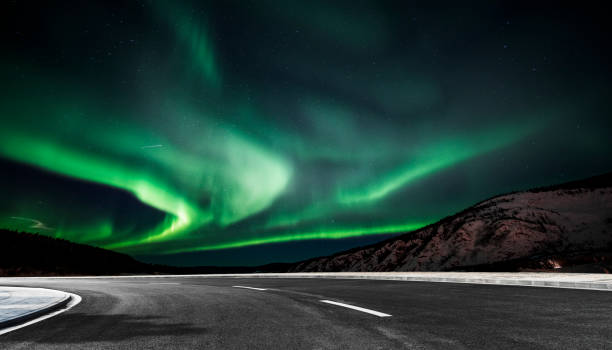 istock aurora borealis over asphalt road in Canada 1046865366