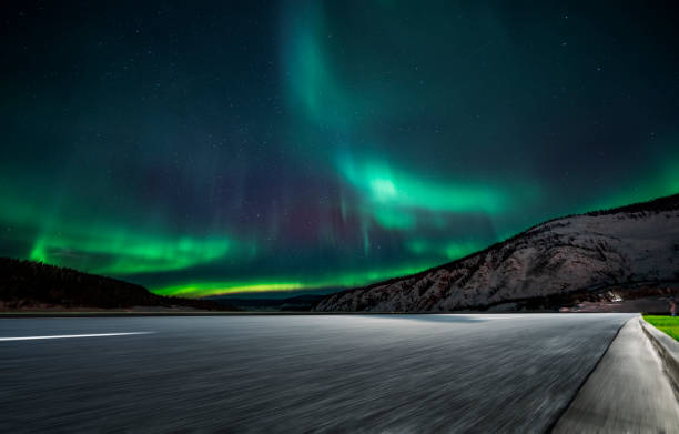 istock aurora borealis over asphalt road in Canada 1046867392