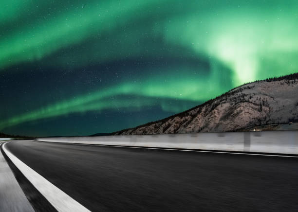 istock aurora borealis over asphalt road in Canada 1046867562