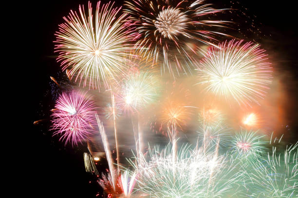 istock Festive colorful fireworks on night sky background. Celebratory holiday 1046872320