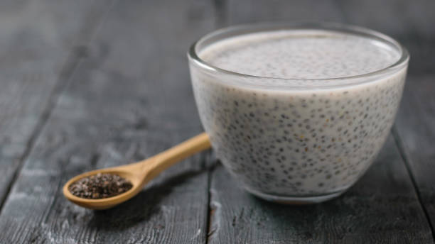 Glass bowl with milk Chia seed pudding on dark wooden table. Glass bowl with milk Chia seed pudding on dark wooden table. Diet food for weight loss and cleansing the body. chia seed photos stock pictures, royalty-free photos & images