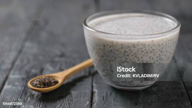 Glass Bowl With Milk Chia Seed Pudding On Dark Wooden Table Stock Photo - Download Image Now