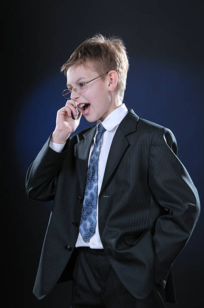 Boy in Suit on Cellphone stock photo