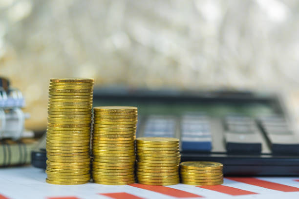 istock Coin stack and financial graph paper sheet with calculator on working table, business planning vision and finance analysis concept. 1046888730