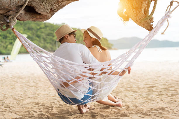 istock Asian couple lying on hammock on beach thailand 1046889030