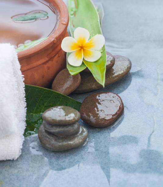istock spa tropical flower with stones for healthy massage 1046889246