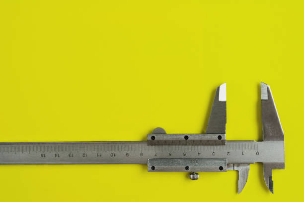 istock Vernier caliper of gray color on yellow table with copy space for your text 1046891468