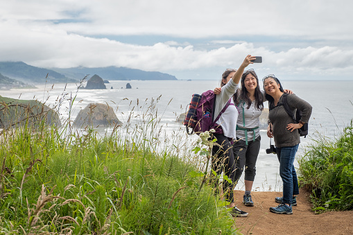 Asian mother and Eurasian daughters at Ecola State Park, Oregon Coast, USA.  Cannon Beach in the background.