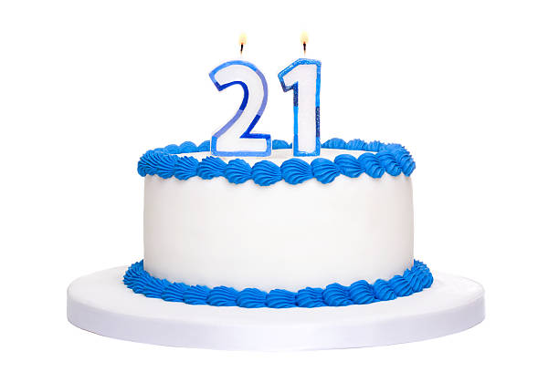 istock White and blue iced birthday cake with twenty one in candles 104690683
