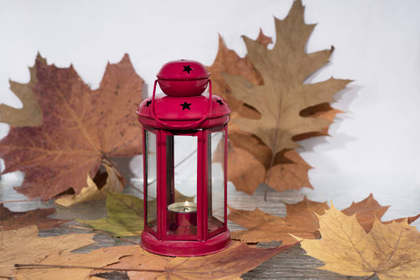 White and red candle lantern with autumn leaves