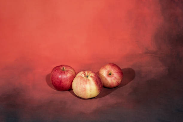 istock Red apples on yellow autumn leaves background 1046928142