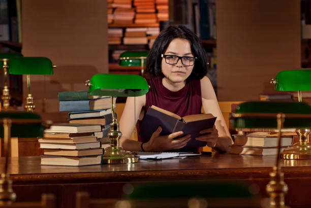 istock girl with books in the library 1046928442