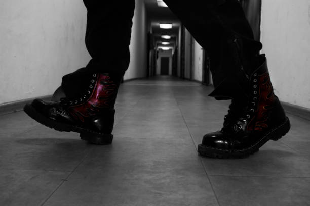 Hipster wearing red trendy boots and coat trench gray background