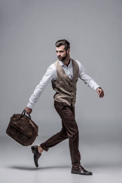 istock hurry stylish man running with leather bag on grey 1046940998