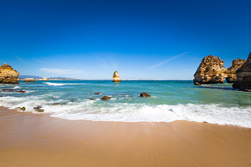 camilo beach scene at lagos, algarve coastline in portugal.
