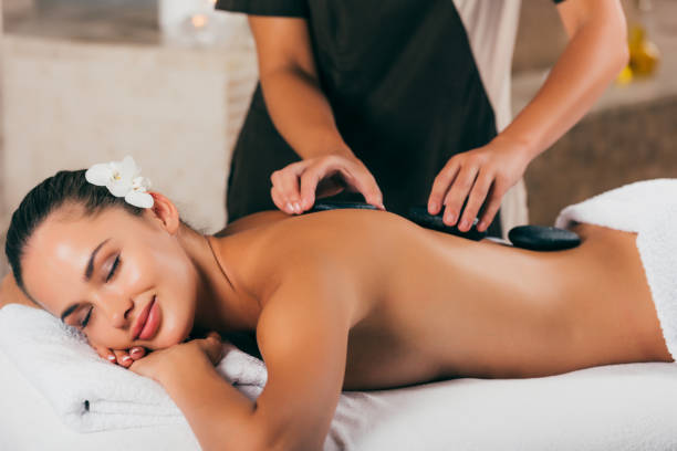 istock smiling young woman having stone therapy at spa salon 1046944200