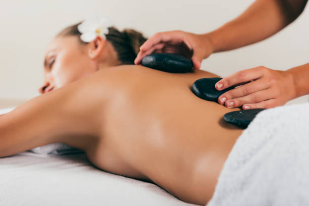 istock relaxing woman having stone therapy at spa salon 1046944218