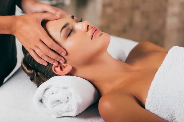 istock young woman relaxing and having face massage 1046944264