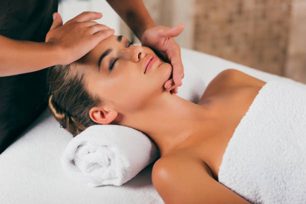 istock happy woman relaxing and having face massage 1046944272