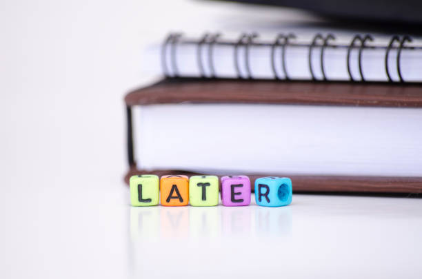 istock procrastination and urgency concept, cube dices with word LATER over white background. Selective focus and shallow depth of field 1046948734