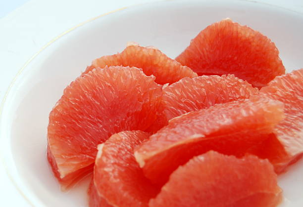 Pink Grapefruit segments, white china stock photo