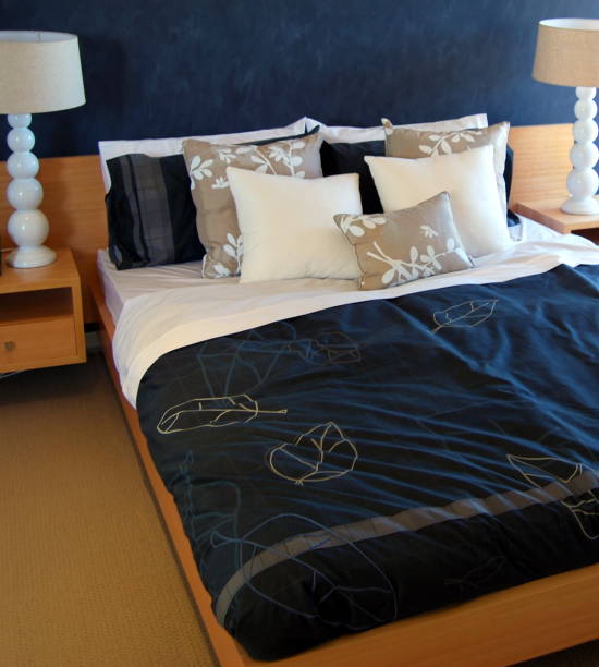 Toned image of a messy bed and electric lamp at nigh. Lot of copy space in the photo.