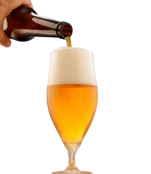 istock Beer from a bottle is poured into a glass. Isolated. 1046962370