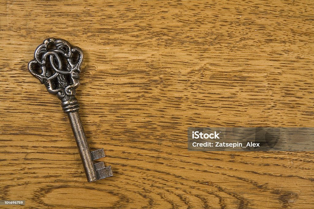 Old key over wood background Old metal key over wood background   Black Color Stock Photo