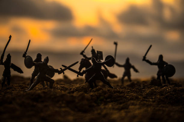 istock Medieval battle scene with cavalry and infantry. Silhouettes of figures as separate objects, fight between warriors on sunset foggy background. 1046974492