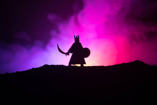 istock Fighter with a sword silhouette a sky. Medieval knight with sword. Selective focus 1046975194