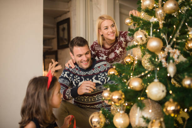 istock Young family decorating Christmas tree 1046986740