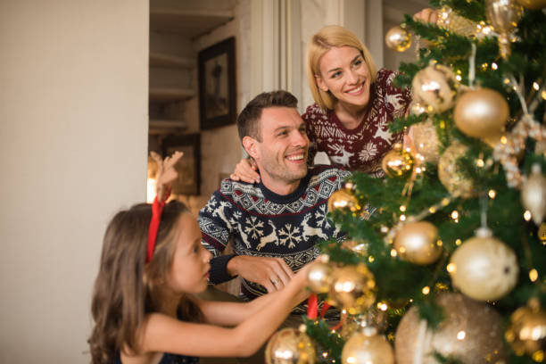 istock Young couple with daughter decorating Christmas tree 1046986838