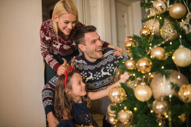 istock Family with a child decorating Christmas tree 1046986930