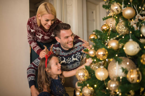 istock Happy couple with a child decorating Christmas tree 1046986940