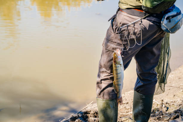 istock Fish hanging on fisherman's belt 1046992420