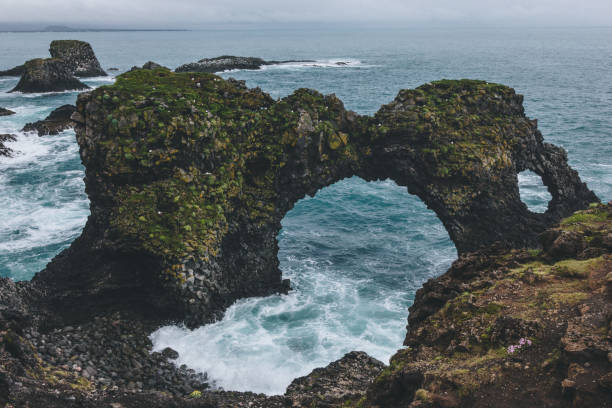 istock dramatic mossy cliffs in front of blue ocean in Arnarstapi, Iceland on cloudy day 1047000848