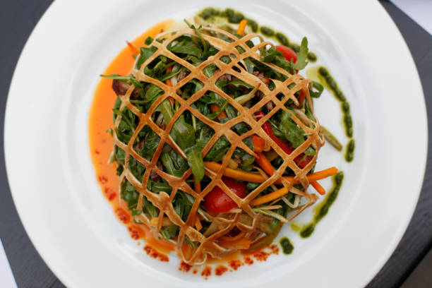 Original serving of Beef Wellington with rocket, salad, cherry tomato, carrot, pesto,