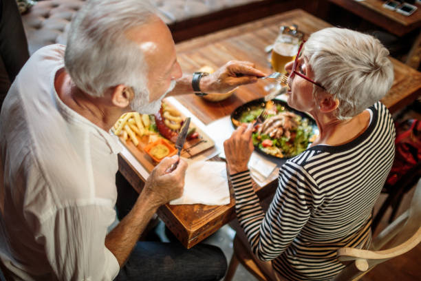 istock Senior man feeding his female partner in the restaurant 1047007370