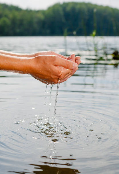 istock Person taking raw unfiltered water from a lake by hands 1047010010