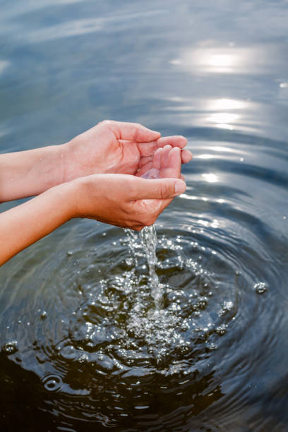 istock Person taking raw unfiltered water from a lake by hands 1047010024