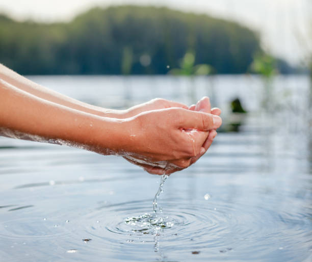 istock Person taking raw unfiltered water from a lake by hands 1047010028