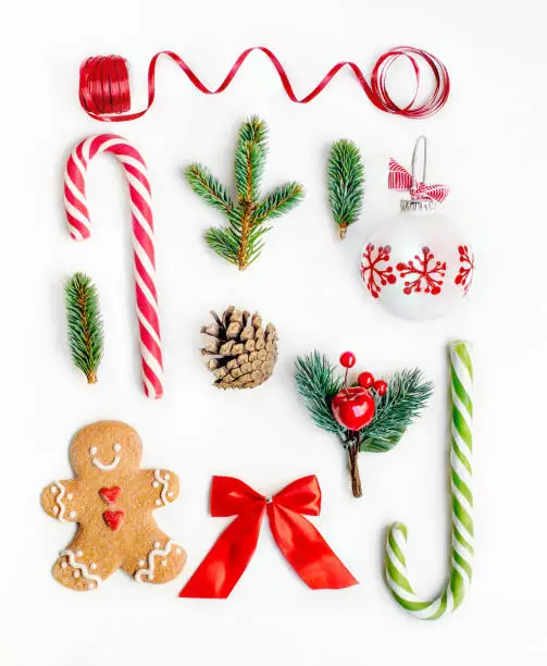 Photo of Flat lay Christmas composition with fir tree branches, gingerbread Christmas Cookie  and holiday ornament on white background. Top view.