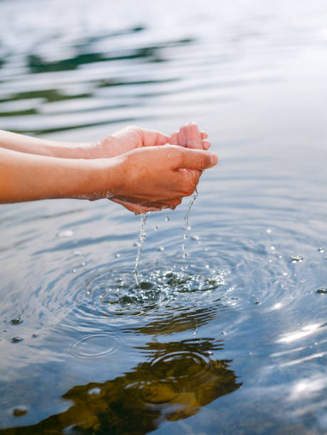 istock Person taking raw unfiltered water from a lake by hands 1047010042