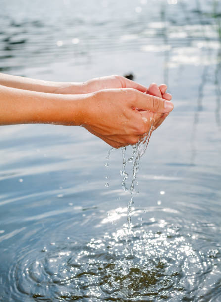 istock Person taking raw unfiltered water from a lake by hands 1047010056