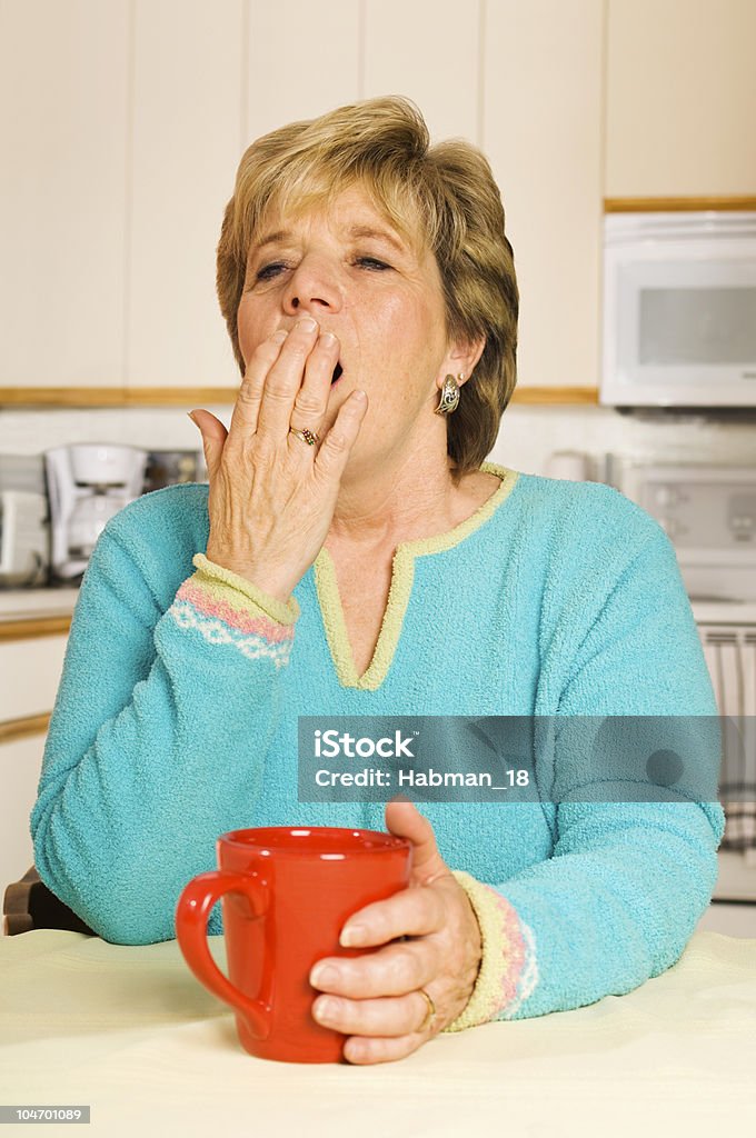 Gähnen Frau mit roten Kaffeebecher in Ihrer Küche - Lizenzfrei Eine Frau allein Stock-Foto