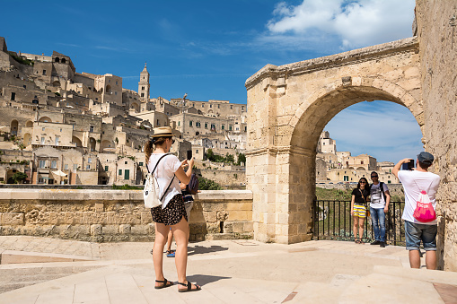 Matera, Italy - August 18, 2018: Tourists take selfies and snapshots with the background of Matera in a sunny day