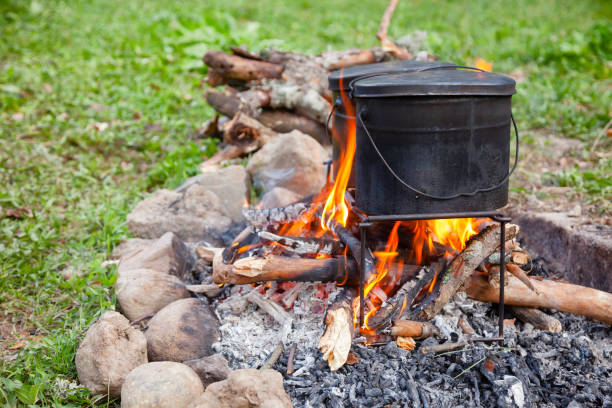 istock Cooking camp food in cauldrons on open fire 1047017294